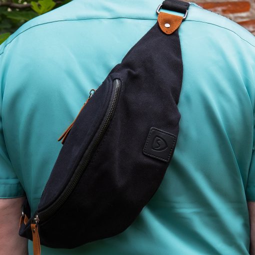 Person bærer sort SYB bæltetaske over skulderen (crossbody)