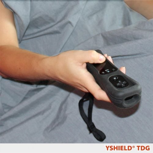 En arm der stikker ud under et Yshield EMF-afskærmende tæppe i Steel-Gray TDG (HF+LF)