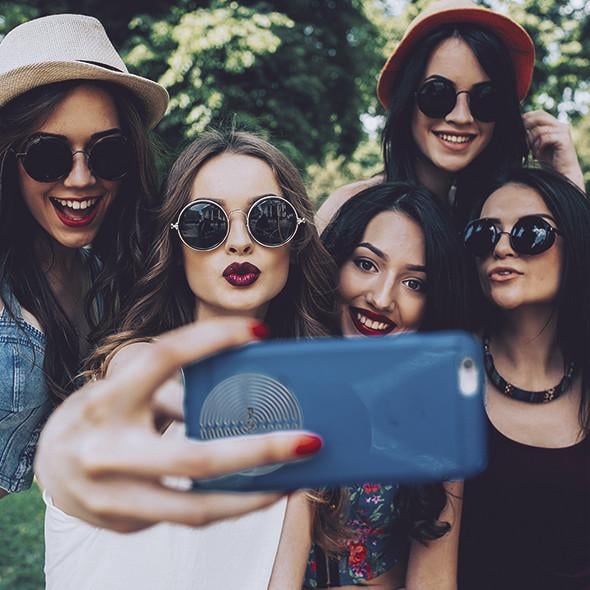 Cool unge kvinder tager selfie med smartphone med FAZUP