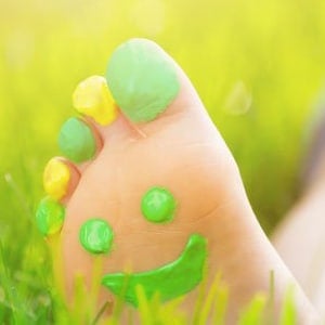 Ikon for artiklen "Fordele ved Earthing" - visende en fod i græsset, med øjne og en glad mund malet på fodsålen