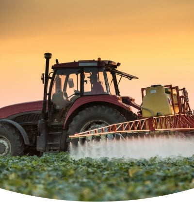 Traktor der sprøjter kemikalier på vores mad